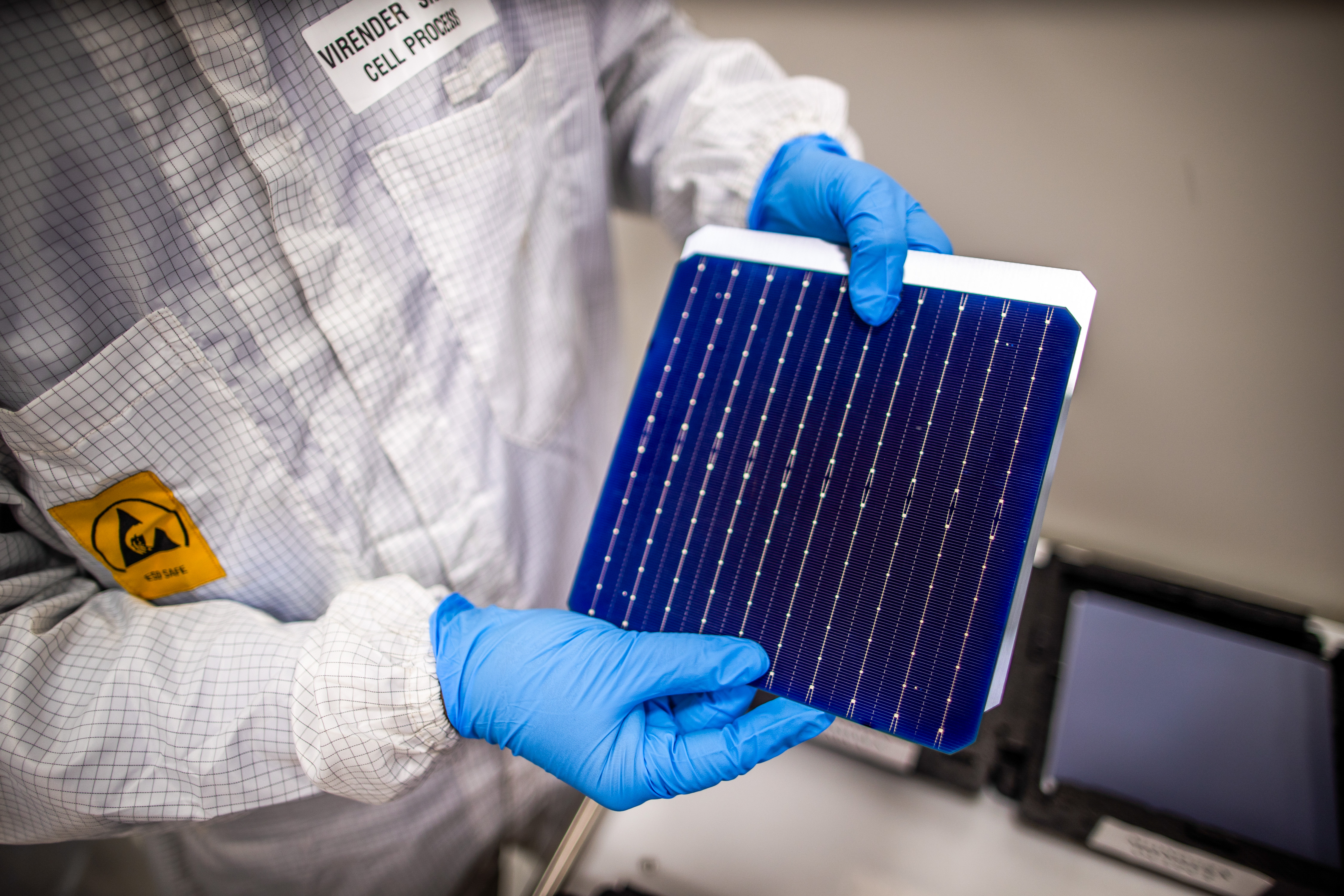 An employee shows a solar cell component on Oct. 30 at an Adani Group factory in Tundra, Gujarat, India. Photo: Bloomberg